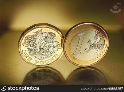 1 pound and 1 euro coin over metal background. 1 pound and 1 euro coin money over metallic background