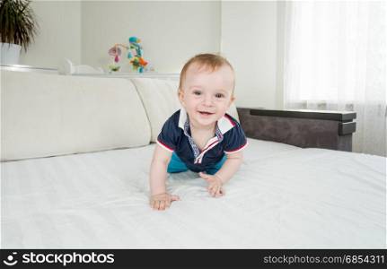 1 year old baby boy crawling on bed