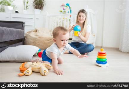 10 months old baby boy playing on floor with colorful toys