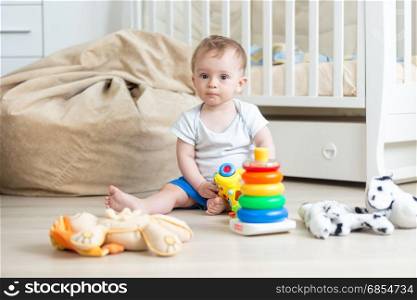 10 months old baby boy playing with colorful toy tower