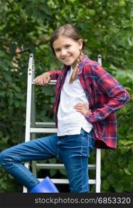 10 year old girl posing at stepladder in garden