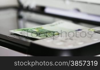 100 euro banknote on flat bed scanner with light moving above it