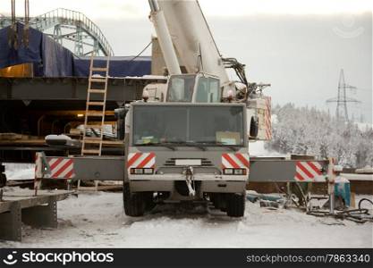 100 ton crane at the construction of the bridge. The snow. Taiga.