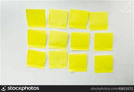 12 blank yellow sticky notes on white board