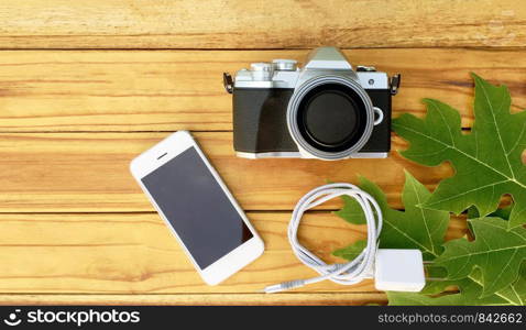 14 July 2019 at Samut Sakhon Thailand people prepare Smartphone and Camera Olympus on wood table vintage before use take photo