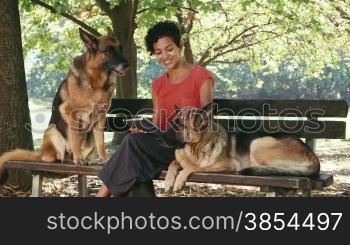14of15 Young people, wi-fi technology and pet, portrait of happy young latina woman working as dog sitter with german shepherd dogs in park, using digital tablet computer for web and e-mail