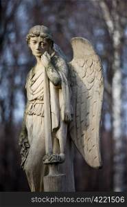 19th century statue of an angel with sad expression on face at Warsaw cemetery in Poland