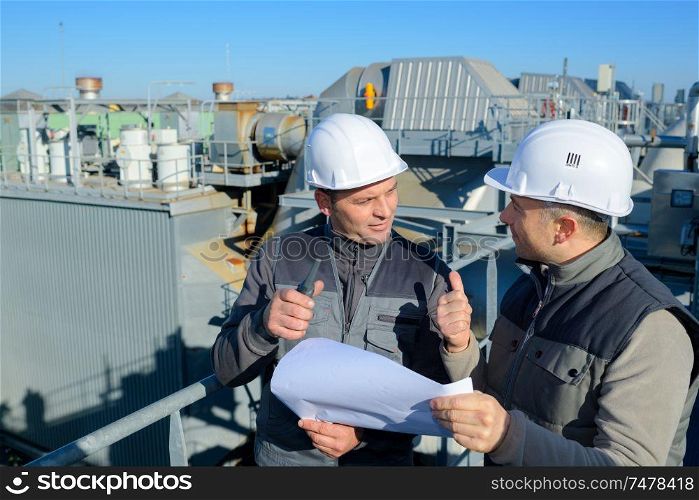 2 engineers check oil refinery