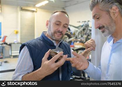 2 engineers discussing component in factory