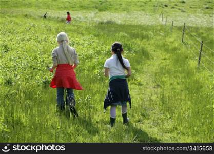 2 girls running in a green field in spring