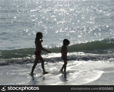 2 girls walking along the seashore