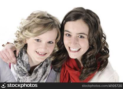 2 teenage girls smiling at camera on white background