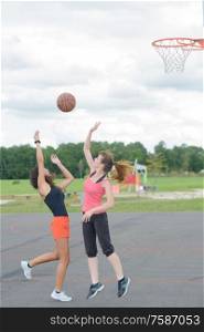 2 women are playing basketball