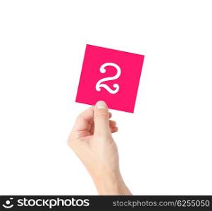 2 written on a card held by a hand