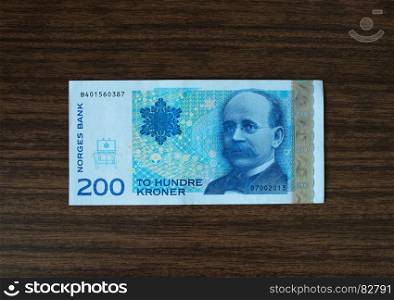 200 Norwegian krones face on wood desk background. 200 Norwegian krones face on wood desk background hd