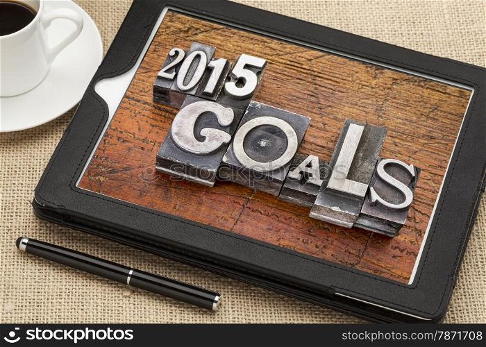 2015 goals - New Year resolution concept - text in vintage metal type blocks against grunge wood on a digital tablet with a cup of coffee