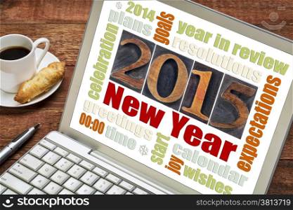 2015 New Year concept - word cloud on a laptop screen with a cup of coffee