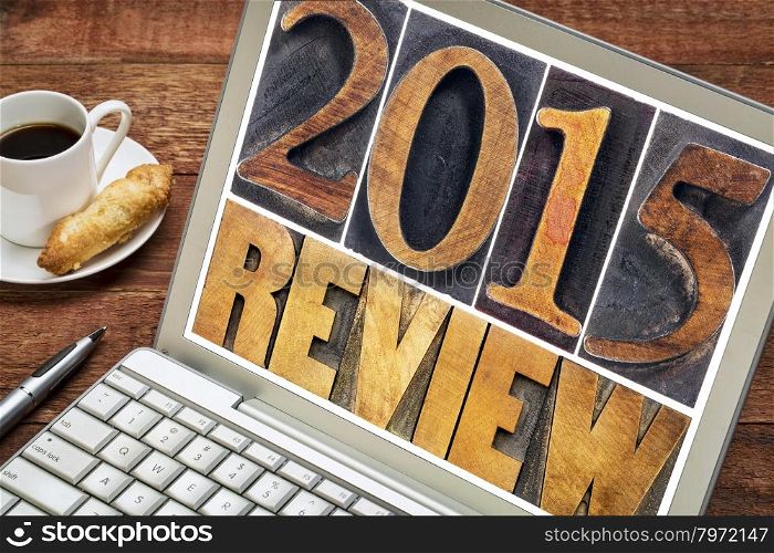 2015 review - annual review or summary of the recent year - text in letterpress wood type blocks on a laptop screen with a cup of coffee