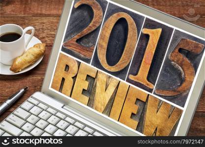 2015 review - annual review or summary of the recent year - text in letterpress wood type blocks on a laptop screen with a cup of coffee