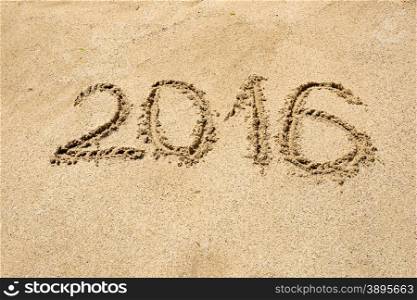2016 digits written on wet sand at beach