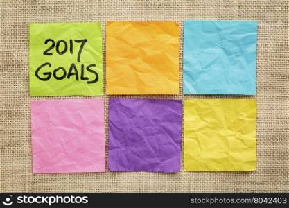 2017 New Year goals - handwriting on a sticky note against burlap canvas with blank notes