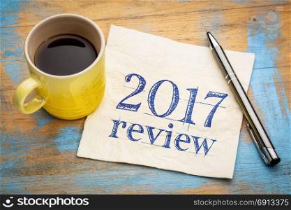2017 review text on a napkin with coffee against grunge wood desk