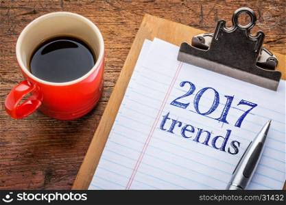 2017 trends on a clipboard with coffee against grunge wood desk