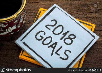 2018 goals - handwriting in black ink on a sticky note with a cup of coffee, New Year resolutions concept