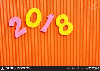 2018 in pink and yellow numbers isolated against an orange background