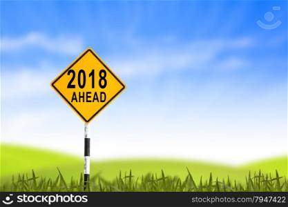 2018, Road sign in the grass field to new year and blue sky, can use as abstract background