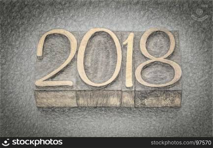 2018 year in letterpress wood type blocks against gray slate stone, digital charcoal painting effect