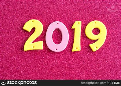 2019 in pink and yellow numbers on a pink background