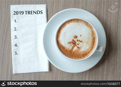 2019 TRENDS word with hot cappuccino coffee cup on table background at the morning. New Year New Start, Resolution, Solution, Strategy and Mission concept