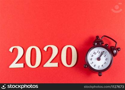 2020 and black alarm clock on red background