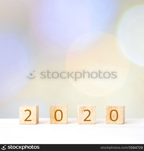 2020 happy new year on wooden block cubes over blur bokeh background, banner with copy space for text, new year greeting card template poster, wallpaper, backdrop