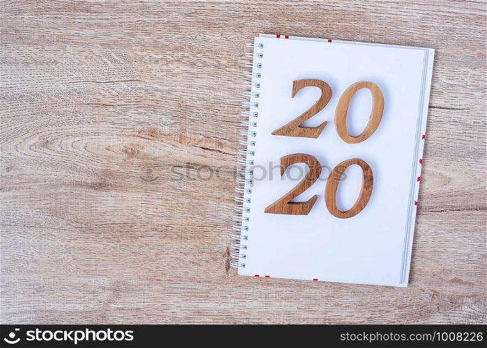2020 Happy New years with blank notebook for text and wooden number on table and copy space. New Start, Resolution, Goals and Mission Concept