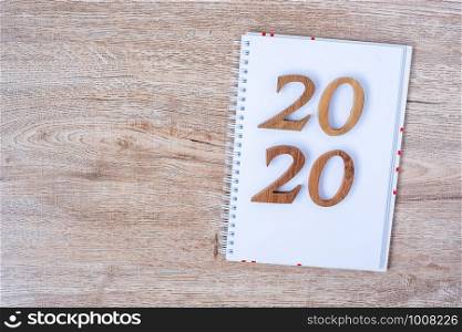 2020 Happy New years with blank notebook for text and wooden number on table and copy space. New Start, Resolution, Goals and Mission Concept