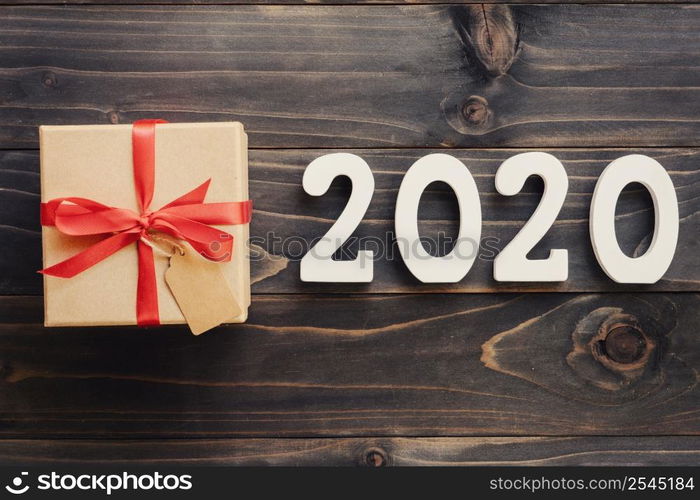 2020 New year concept : 2020 wood number and brown gift box on wood table background.