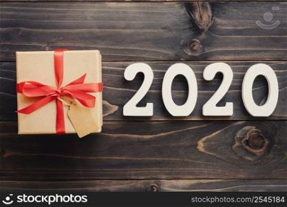 2020 New year concept : 2020 wood number and brown gift box on wood table background.