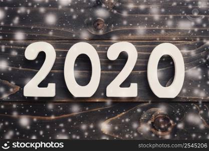 2020 New year concept : 2020 wood number with snow on table background.