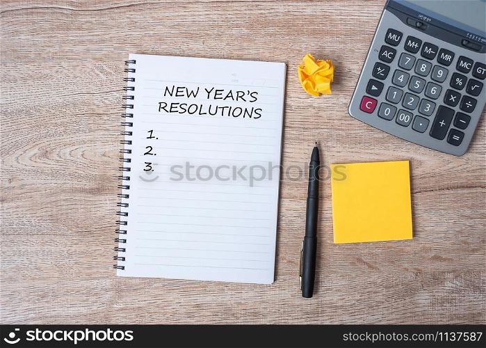 2020 NEW YEAR RESOLUTION word on note with pen and crumbled paper on wooden table background. NEW START, Strategy and Goal concept