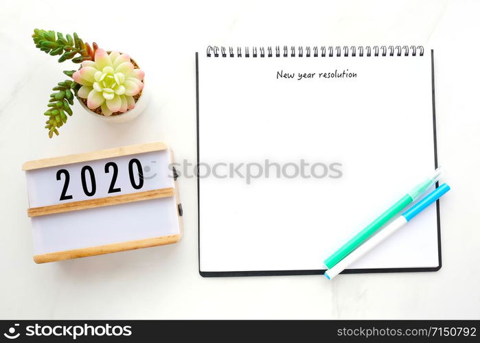 2020 resolution on blank notebook paper over white marble background, 2020 new year mock up, template, flat lay