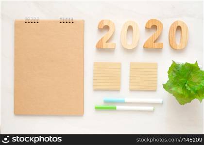 2020 wooden letters and blank notebook paper background with copy space for text, new year background banner concept