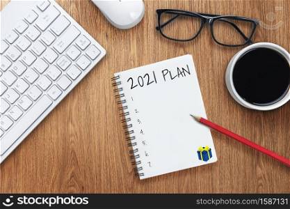 2021 Happy New Year Resolution Goal List - Business office desk with notebook written in handwriting about plan listing of new year goals and resolutions setting. Change and determination concept.