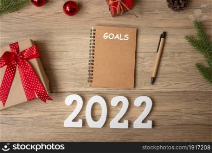 2022 GOAL with notebook, Christmas gift and pen on wood table. Xmas, Happy New Year, Resolution, To do list, start, Strategy and Plan concept