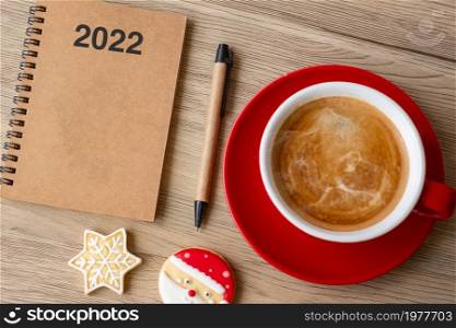 2022 GOAL with notebook, coffee cup, Christmas cookies and pen on wood table. Xmas, Happy New Year, Resolution, To do list, Strategy and Plan concept