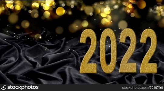 2022 greeting card with year written with golden figures on dark fabric and blur lights background