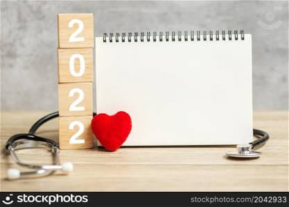 2022 Happy New Year for healthcare, Insurance, Wellness and medical concept. Stethoscope and blank notebook for copy space your text