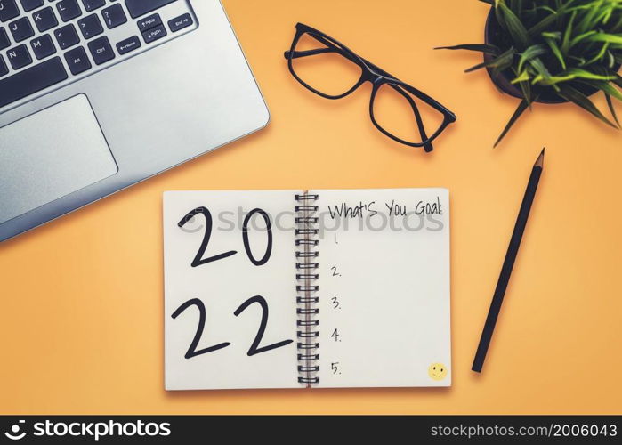 2022 Happy New Year Resolution Goal List and Plans Setting - Business office desk with notebook written about plan listing of new year goals and resolutions setting. Change and determination concept.. 2022 Happy New Year Resolution Goal List and Plans Setting