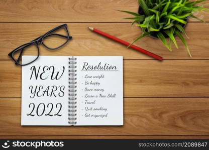 2022 Happy New Year Resolution Goal List and Plans Setting - Business office desk with notebook written about plan listing of new year goals and resolutions setting. Change and determination concept.